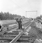 859266 Afbeelding van wegwerkers van de N.S. tijdens het leggen van spoor met zig-zag dwarsliggers.